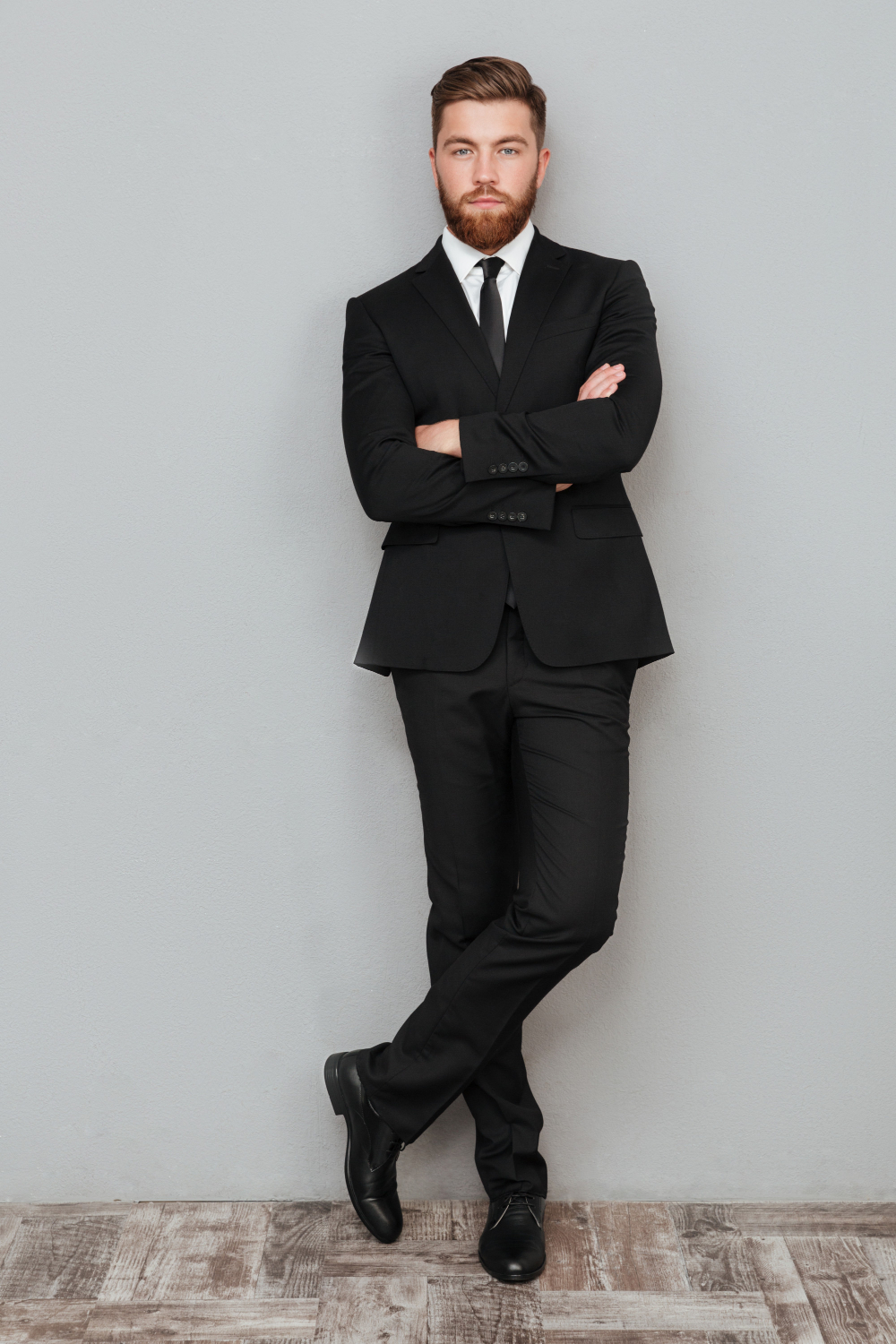 Groom holding his tailored jacket during a final fitting